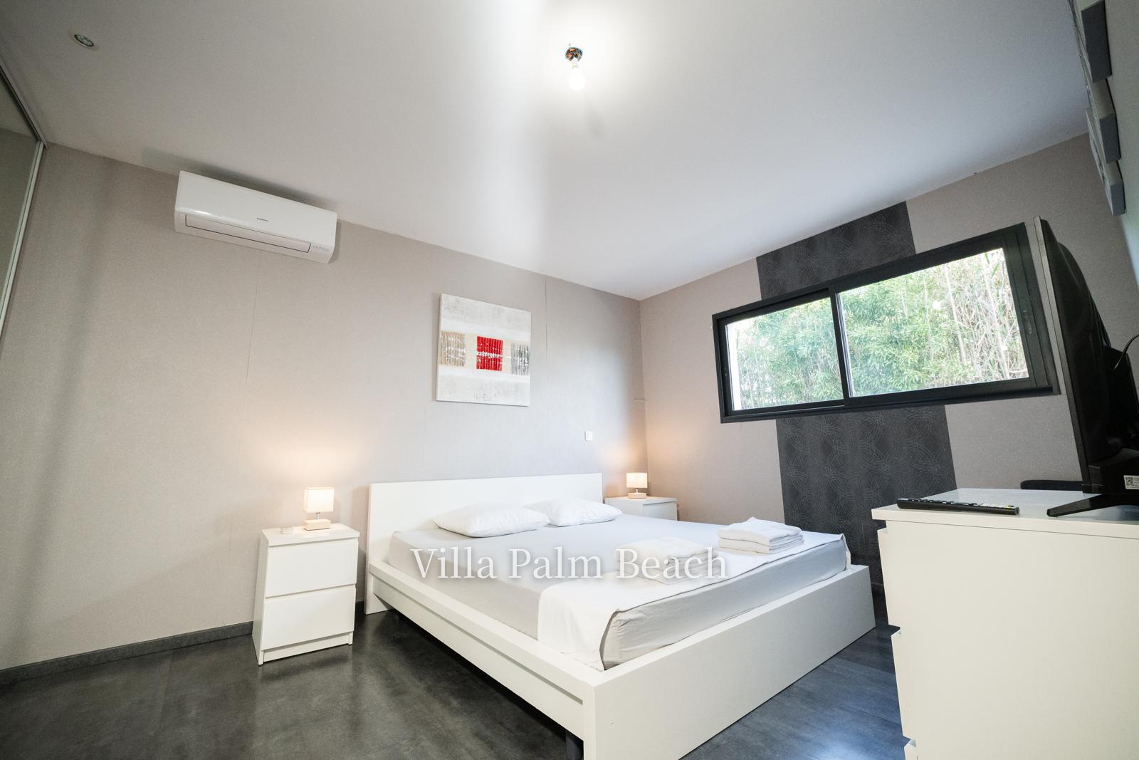 Chambre climatisée avec lit double et fenêtre sur les bambous